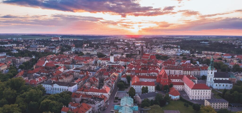 Panorama miasta z lotu ptaka z czerwonymi dachami starówki o zachodzie słońca – doradztwo podatkowe Kalisz